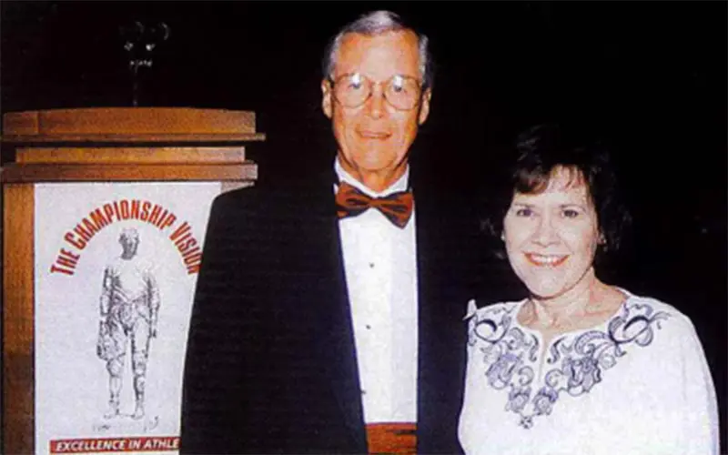A man and woman in dress clothes posing for photo
