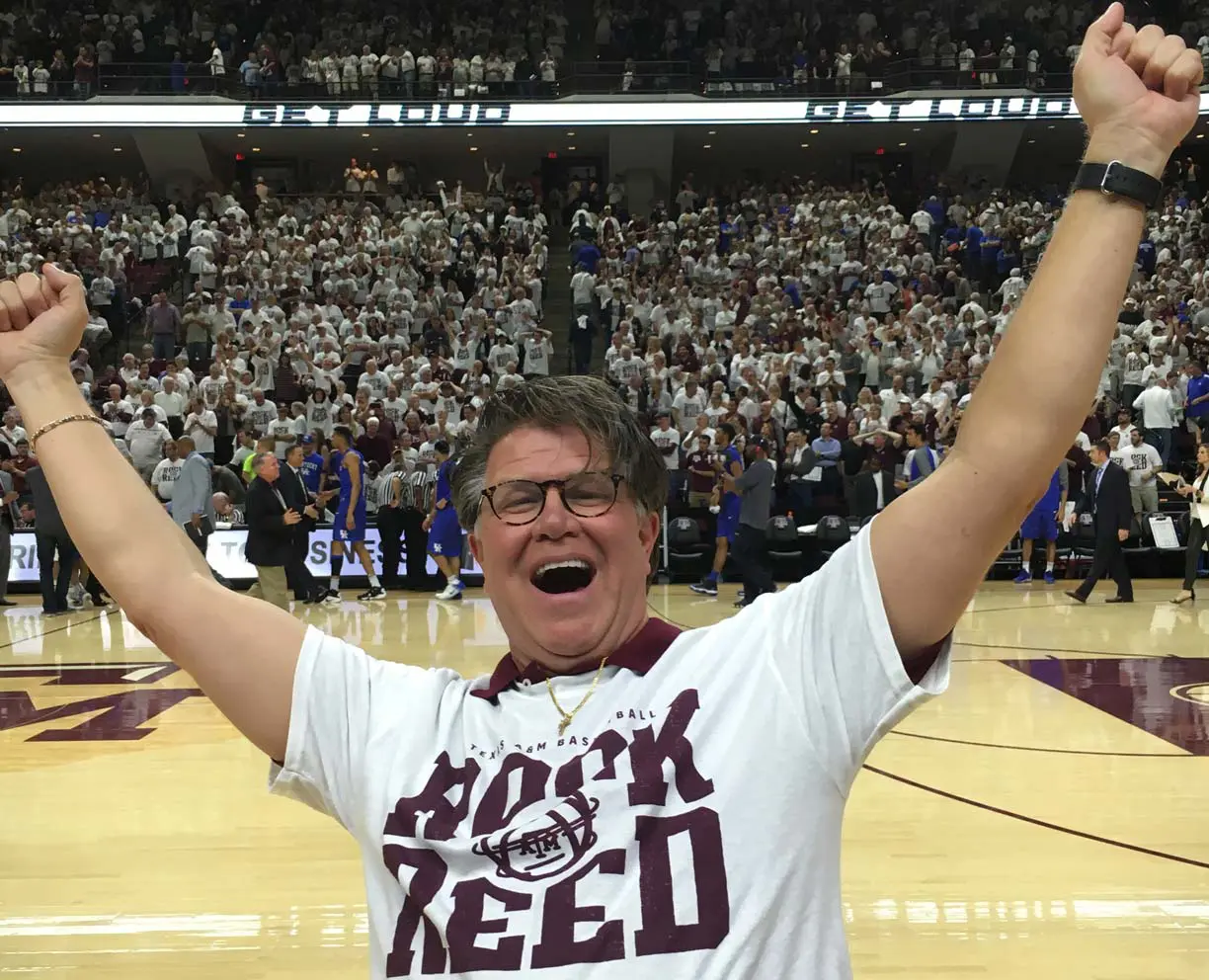 A man on the side court with his arms in the air